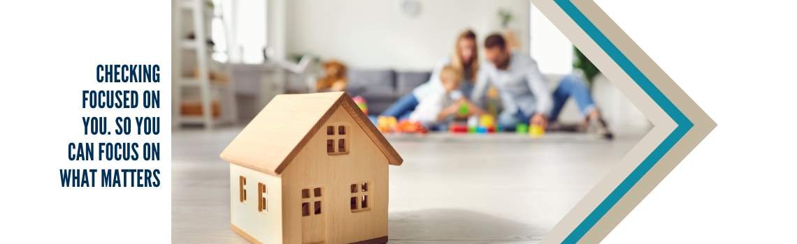 "A wooden toy house in the foreground with a family playing together in the blurred background. Text on the left reads 'Checking focused on you. So you can focus on what matters.'"