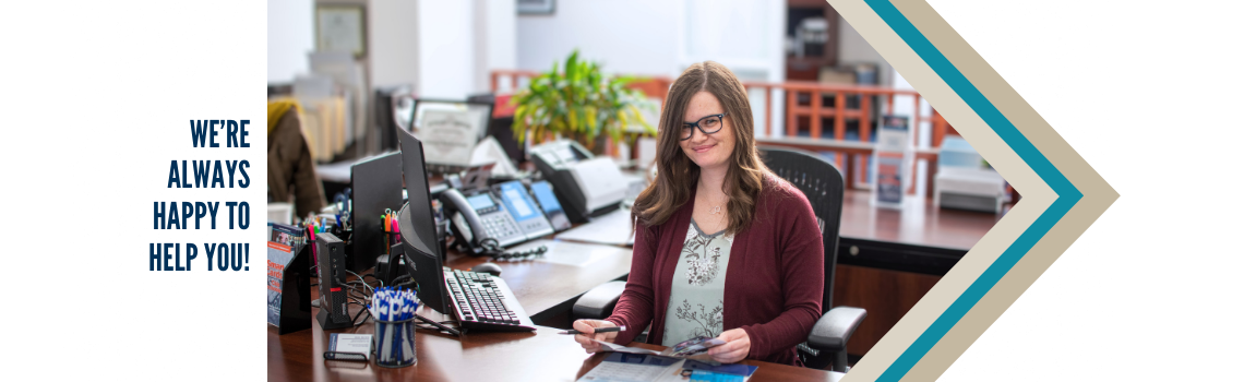 "Sara, a smiling female employee, sitting at a desk with multiple phones and office supplies. Text on the left reads 'We are always happy to help you!'"